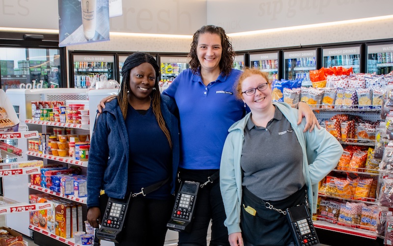 Quantum Services Team together smiling in a convenience store with their equipment